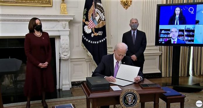 조 바이든 미국 대통령이 21일(현지시간) 백악관에서 카말라 해리스 부통령(왼쪽)과 앤서니 파우치 국립알레르기·전염병연구소 소장(오른쪽)이 지켜보는 가운데 코로나19 대응에 관한 행정명령에 서명하고 있다. / 사진 = 유트뷰 캡처