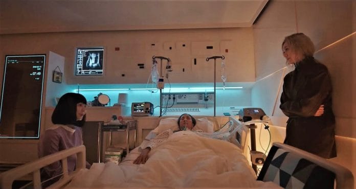 ▲AI 로봇 간호중(사진 왼쪽)과 10년 동안 식물인간으로 누워 있는 어머니를 간병하는 딸 연정인(사진 오른쪽)이 이야기를 나누고 있다. /사진=유튜브 캡처