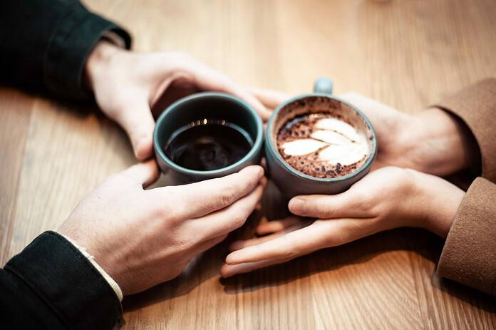 ▲두 사람이 손을 커피 잔에 대고 있다. ⓒUnsplash